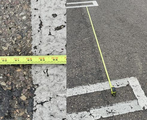 A tape measure on a parking space to create measurement validation for photogrammetry project